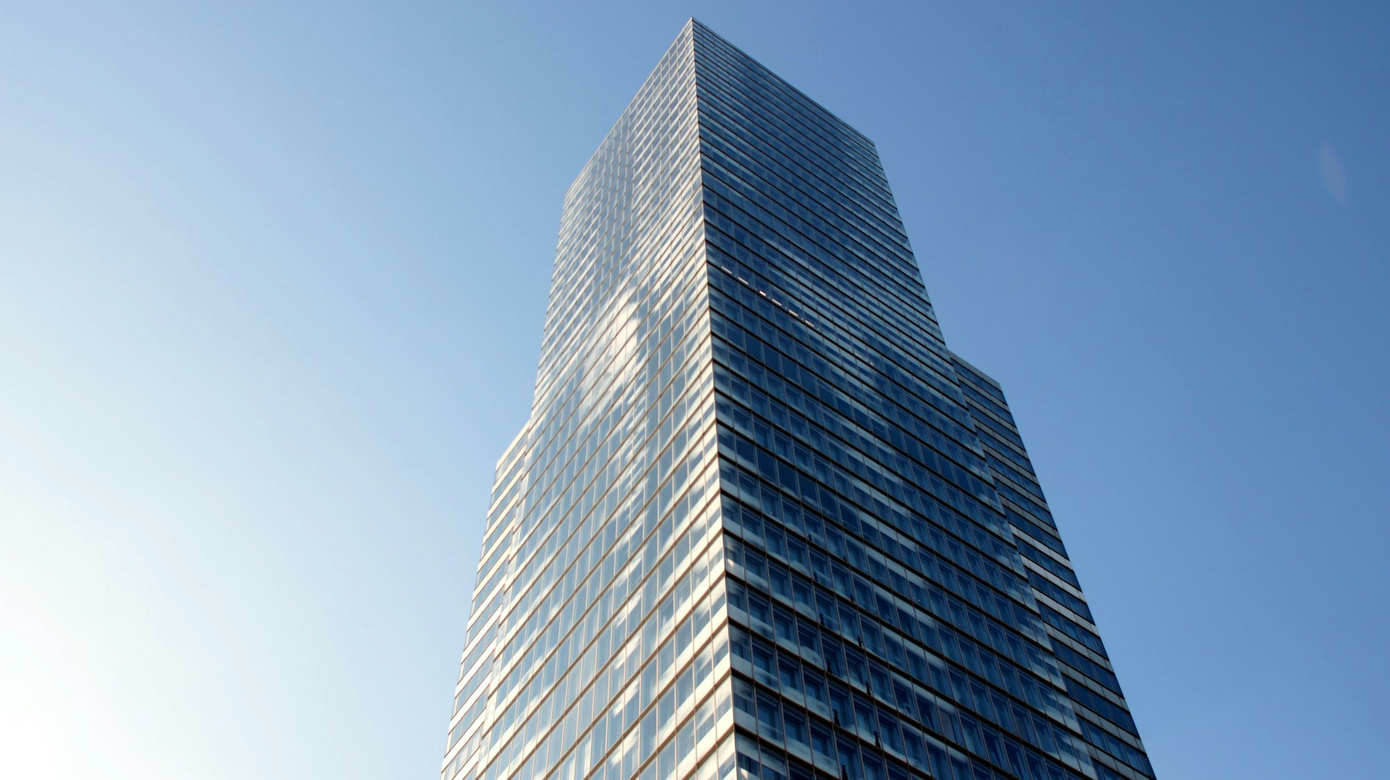 Der Kölnturm am Mediapark von unten fotografiert mit blauem Himmel.