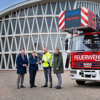 Die vier Männer stehen vor dem Feierabendhaus in Knapsack und neben ihnen steht der Drehleiterwagen.
