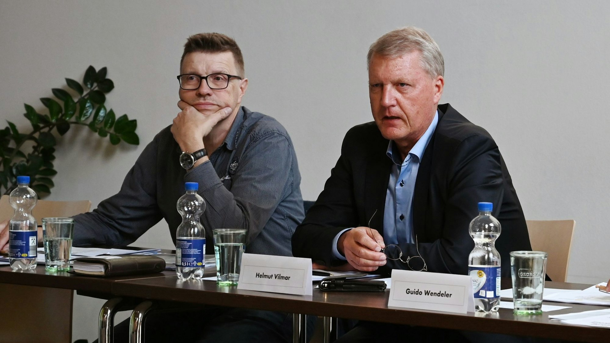 Thomas Willmer und Helmut Vilmar sitzen an einem Tisch nebeneinander.