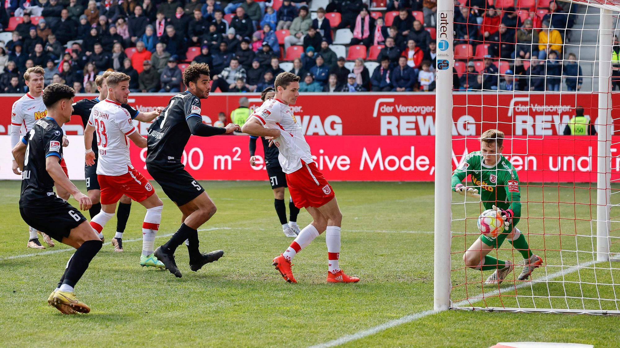Der Regensburger Torhüter Jonas Urbig (r) klatscht einen Kopfball auf der Linie weg.