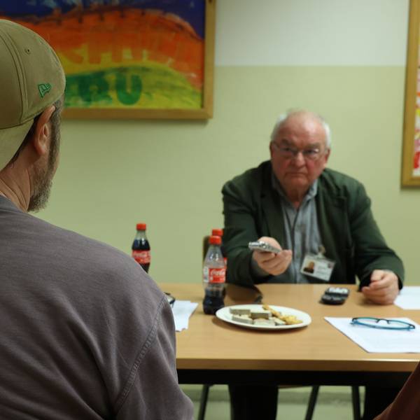 Erzählwerkstatt in der Kölner JVA: Häftling, von dem nur der Rücken zu sehen ist, im Gespräch mit Klaus Jünschke.