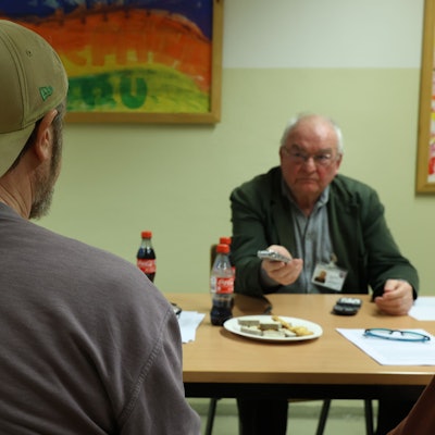 Erzählwerkstatt in der Kölner JVA: Häftling, von dem nur der Rücken zu sehen ist, im Gespräch mit Klaus Jünschke.