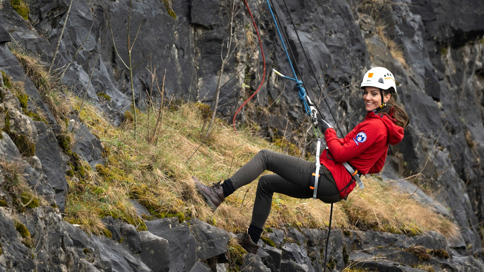 Kate seilt sich an einem Berg ab.