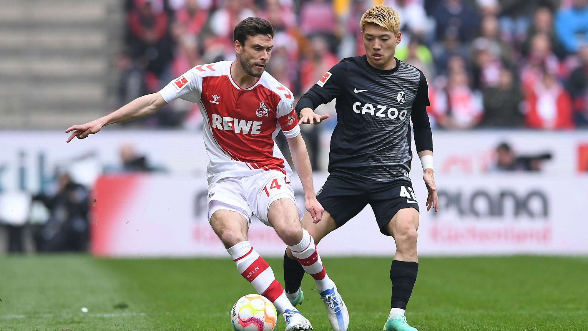 Jonas Hector behauptet den Ball gegen Freiburgs Ritsu Doan.