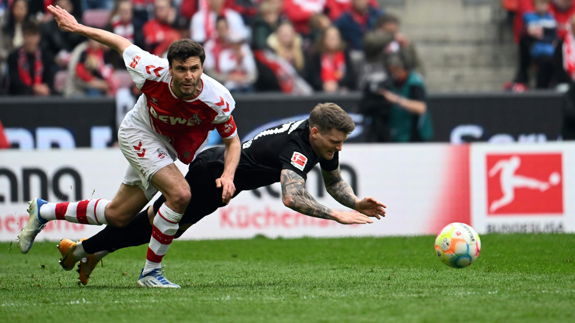 Kölns Jonas Hector (l) und Freiburgs Lukas Kübler kämpfen um den Ball.