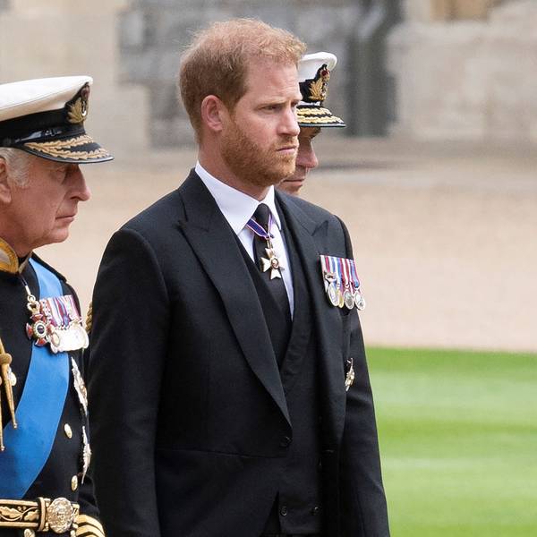 König Charles III. und Prinz Harry gehen auf einem Weg nebeneinander.