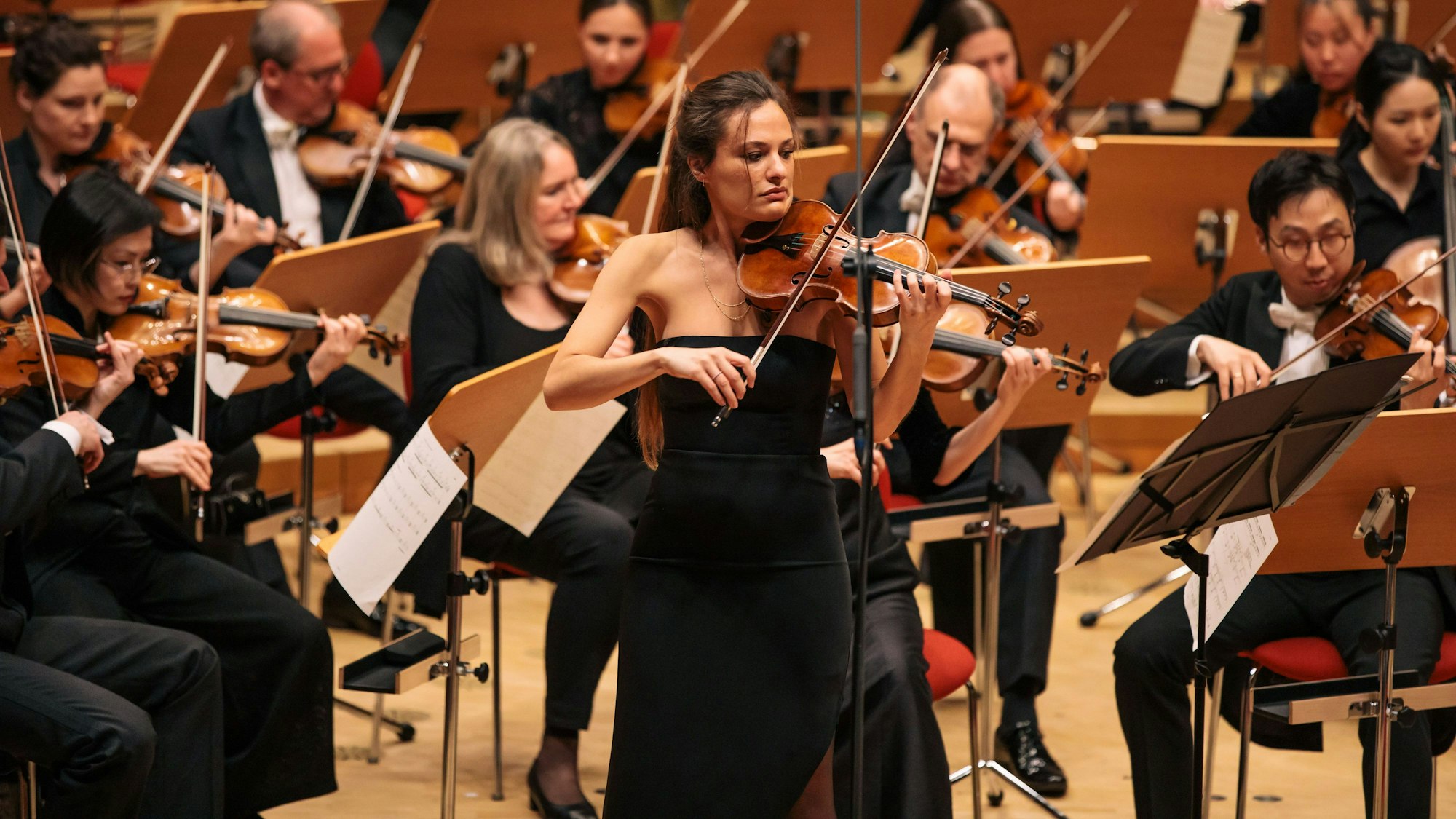 Die italienische Violinistin Nicola Benedetti spielt zur Eröffnung des Acht-Brücken-Festivals am 28. 4. 2023 in der Kölner Philharmonie. Sie trägt ein schulterloses schwarzes Abendkleid.