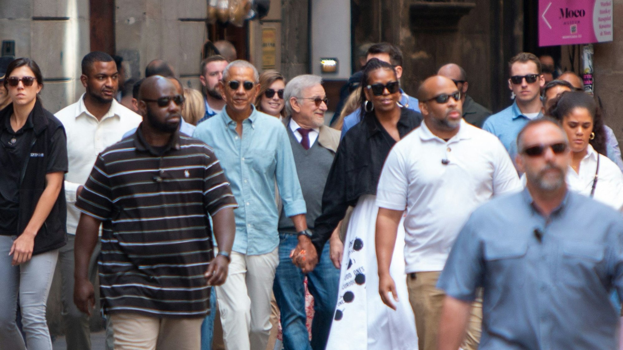 Der ehemalige US-Präsident Barack Obama und seine Frau Michelle gehen durch eine Straße in Barcelona.