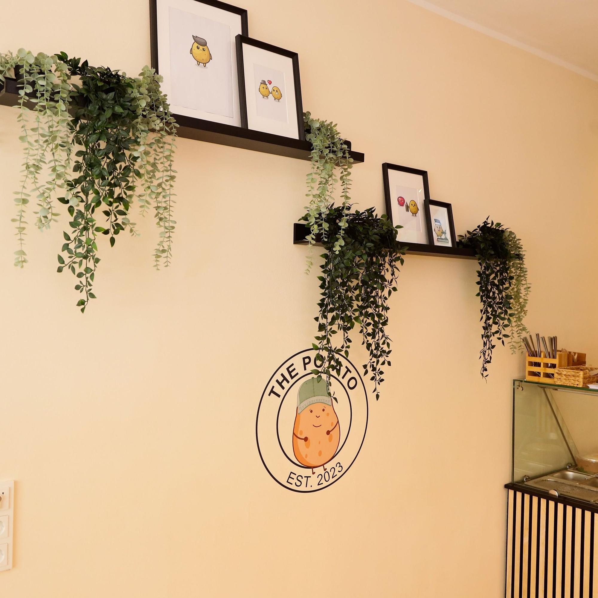 An der Wand sind Bilder der Comic-Kartoffel.