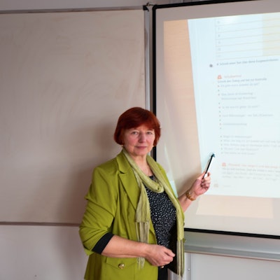 Eine Lehrerin steht an einem Smartboard in einer Schule.