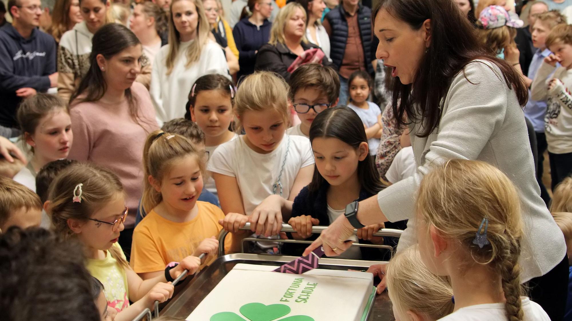 Rektorin Britta Bockschewsky wird bei der Eröffnungsfeier der Fortunaschule von Kindern umringt.