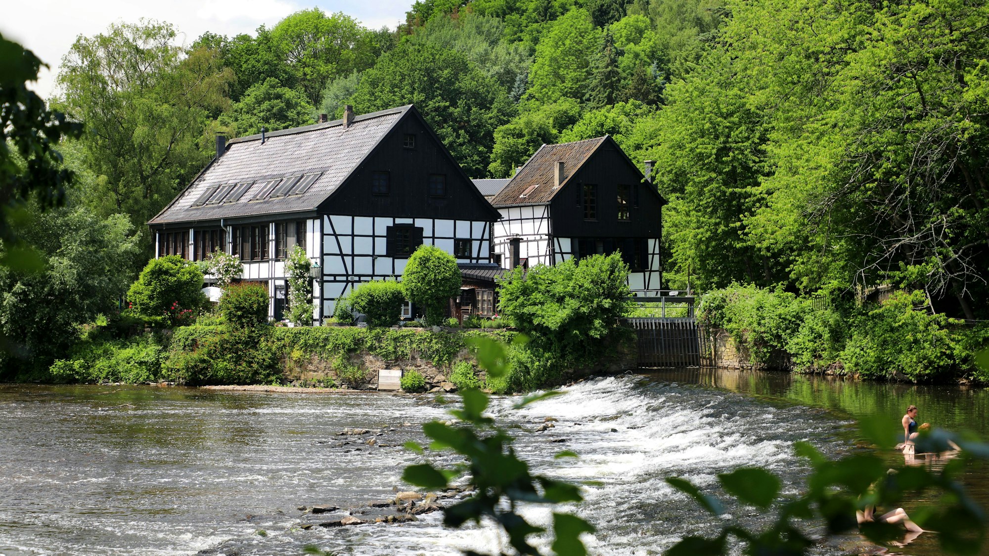 zwei Fachwerkgebäude an einem Fluss