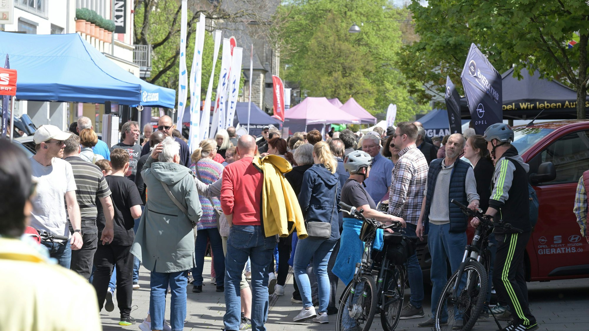 Es ist eine Straße in Bergisch Gladbach zu sehen, auf der viele Menschen sich bewegen. Am Rand stehen mehrere Verkaufs- und Infostände.