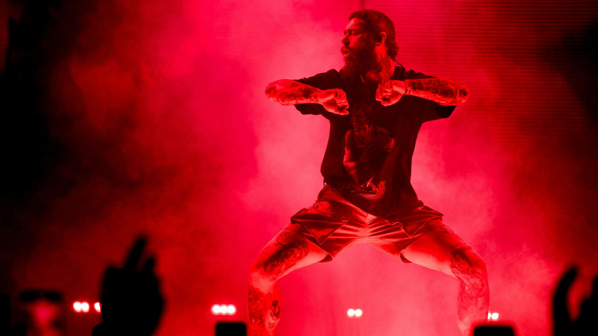 Post Malone am 1. Mai 2023 in der Kölner Lanxess-Arena. Er trägt ein Dirk-Nowitzki-T-Shirt und Khaki-Shorts.