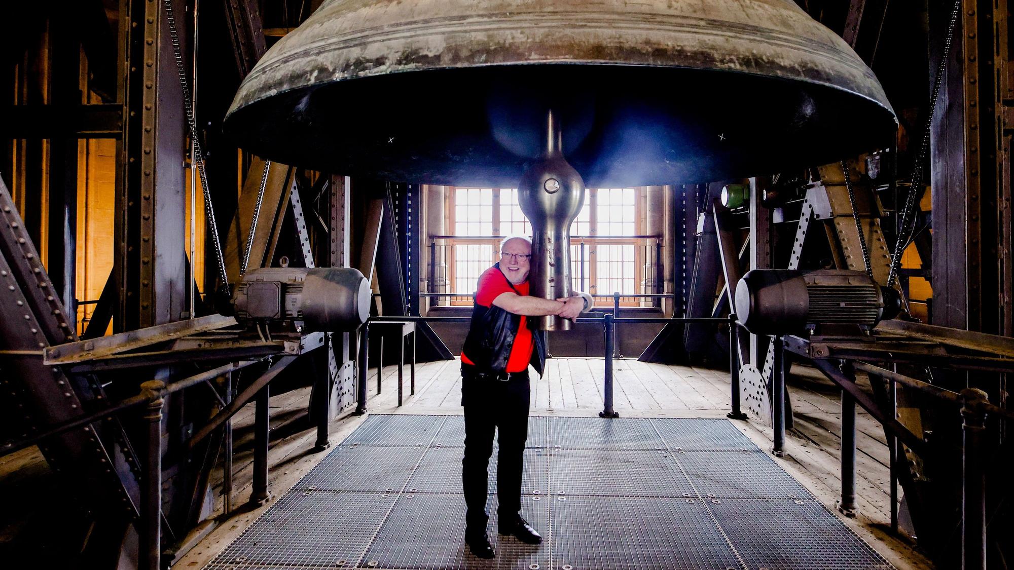 Karnevalist und Priester Willibert Pauels umarmt die Glocke im Dom.