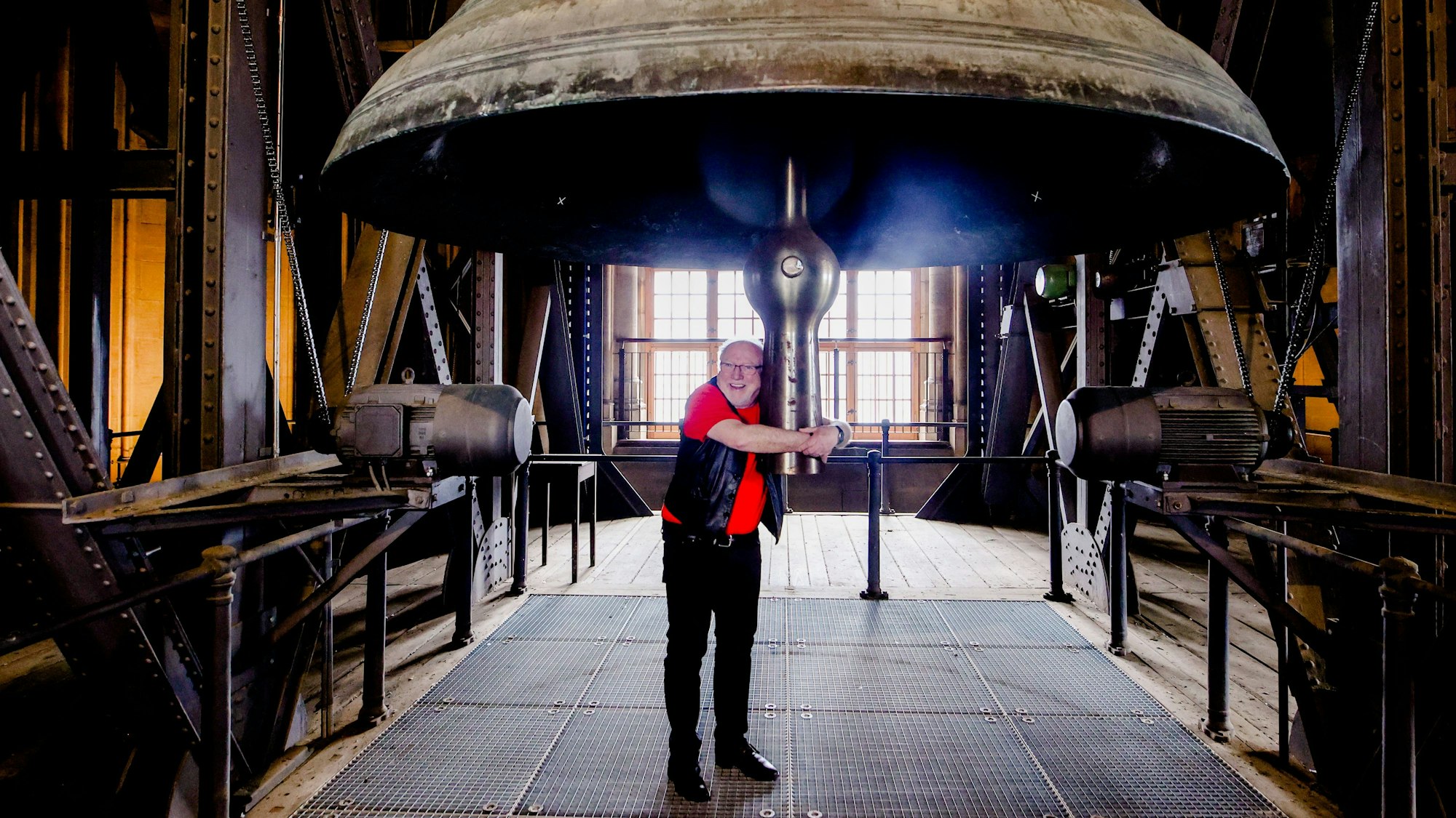 Karnevalist und Priester Willibert Pauels umarmt die Glocke im Dom.