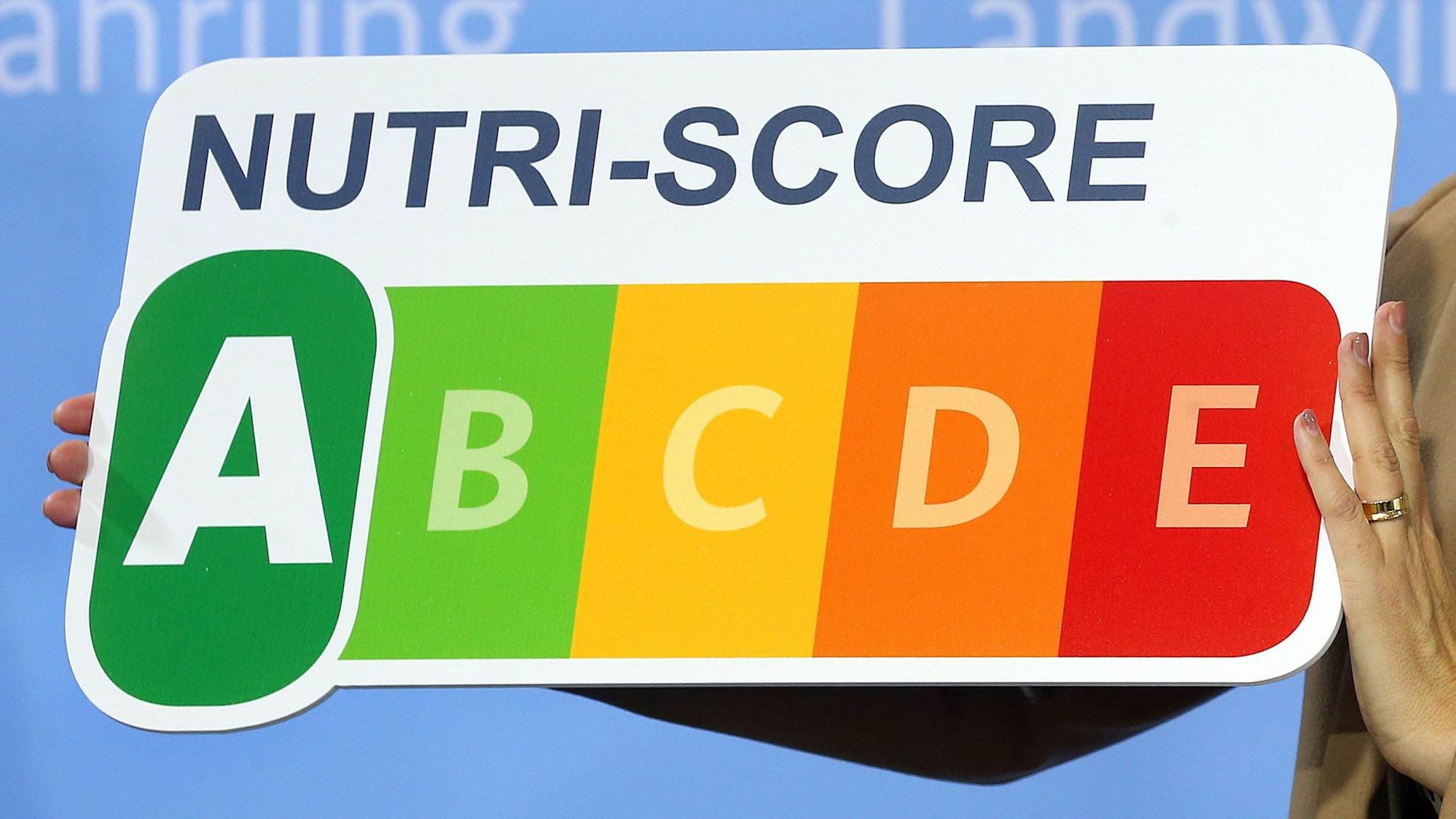 Das Symbol des Lebensmittel-Bewertungssystems Nutri-Score wird auf einer Bühne gezeigt. Lebensmittel werden von A bis E bewertet, je nachdem, wie gesund sie sind.