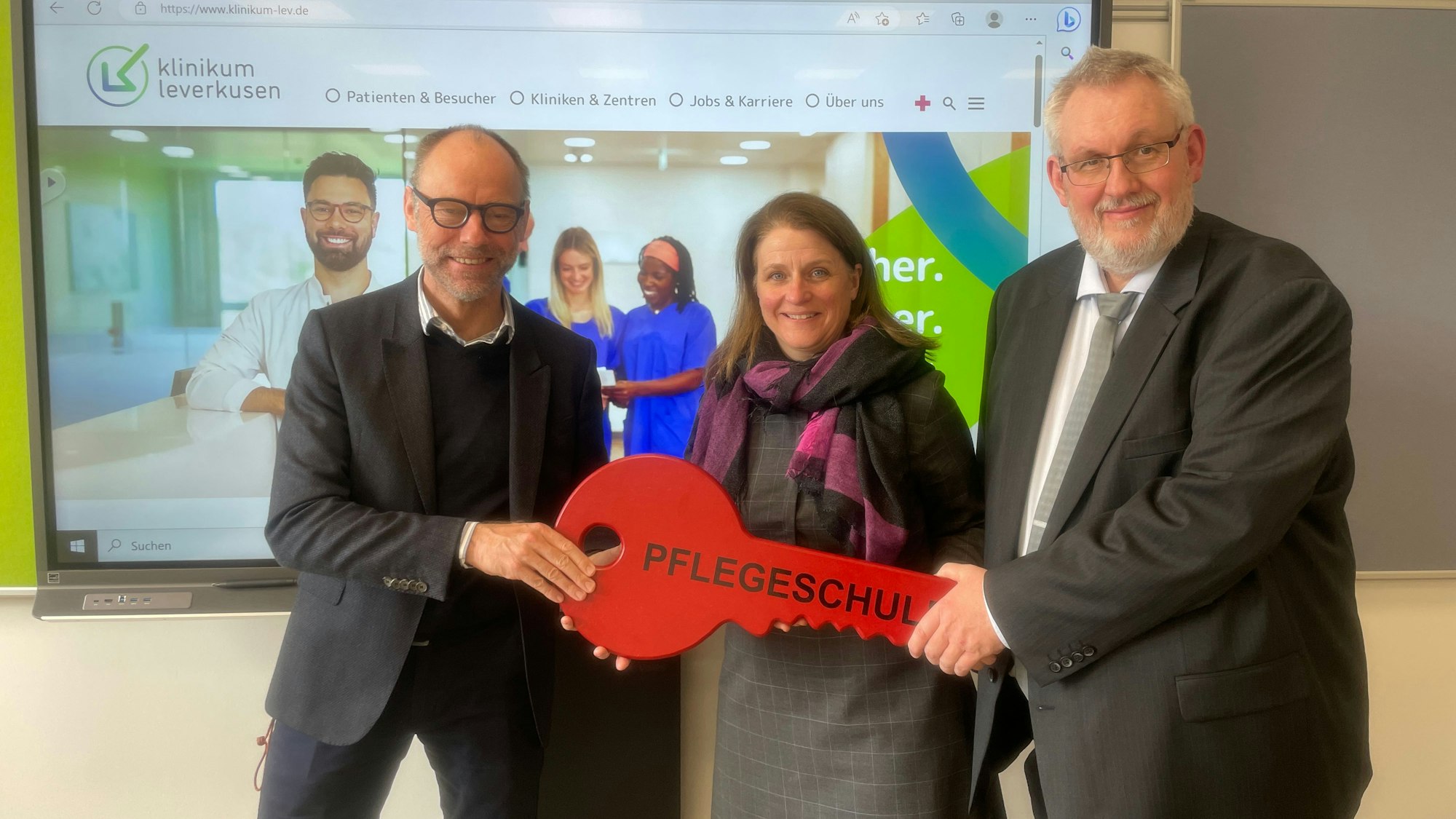 Baulleiter Bernd Hartmann (l.) übergibt den symbolischen Schlüssel zum neuen Gebäude der Pflegeschule am Klinikum Leverkusen an Geschäftsführerin Anja Mitrenga-Theusinger und Schulleiter Frank Hansen.