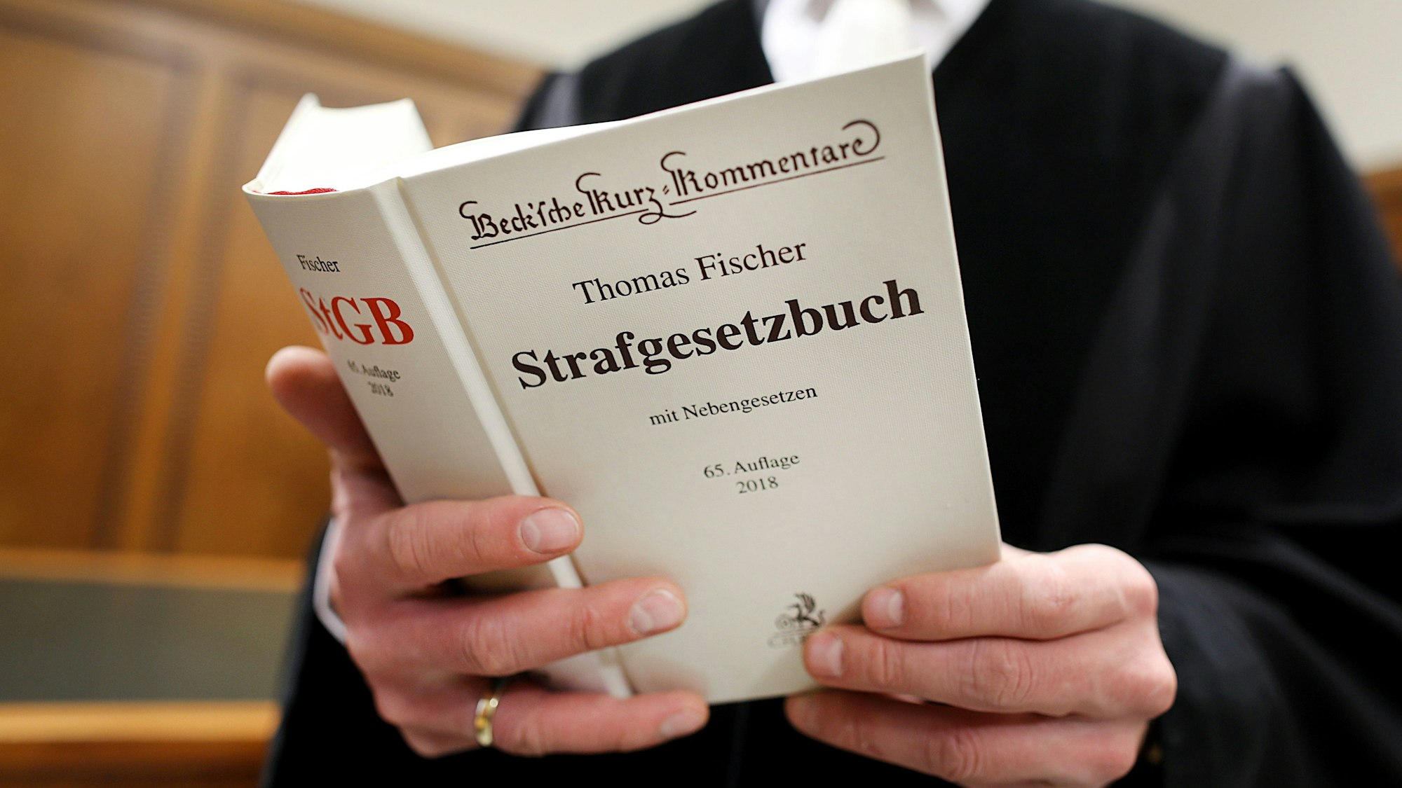 Ein Richter hält ein Strafgesetzbuch in den Händen. Es musste nicht zu Rate gezogen werden, weil das Verfahren gegen den Brühler eingestellt worden ist.