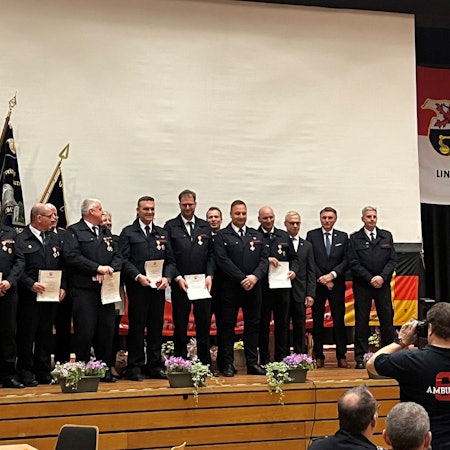 Es sind einige der Feuerwehrmänner auf der Bühne zu sehen.