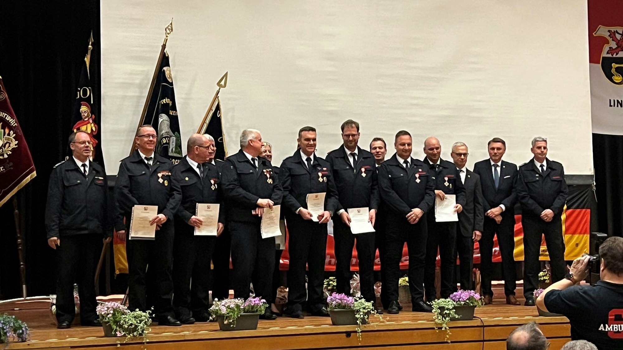 Es sind einige der Feuerwehrmänner auf der Bühne zu sehen.