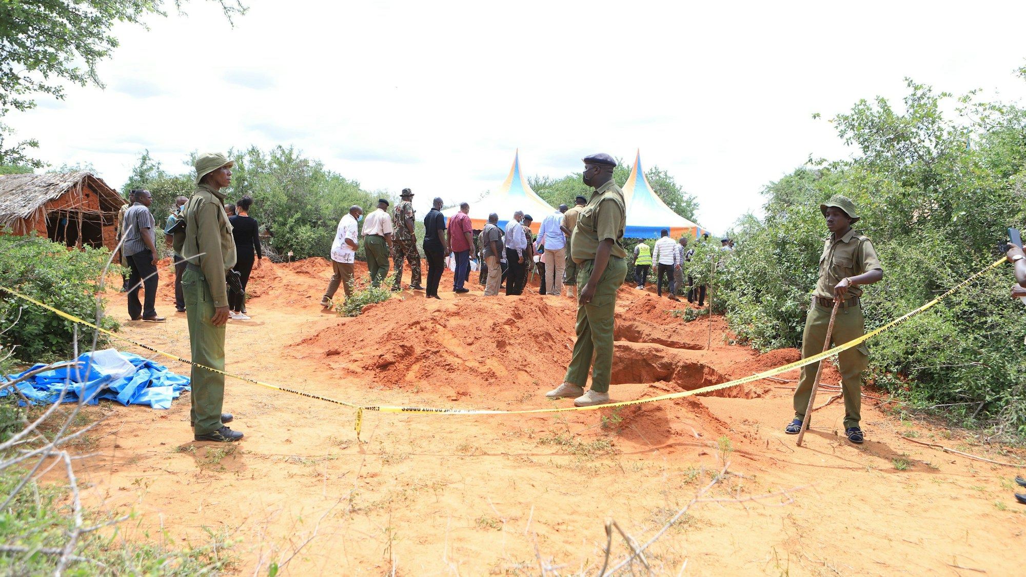 Polizeibeamte stehen in Kenia neben einer Absperrung vor Gräbern, aus denen die Polizei die Leichen von Opfern eines christlichen Sektenkults exhumiert. (Archivbild)