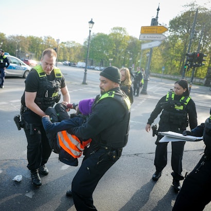 Letzte Generation in Berlin: Polizisten tragen eine Klima-Aktivistin von der Straße.