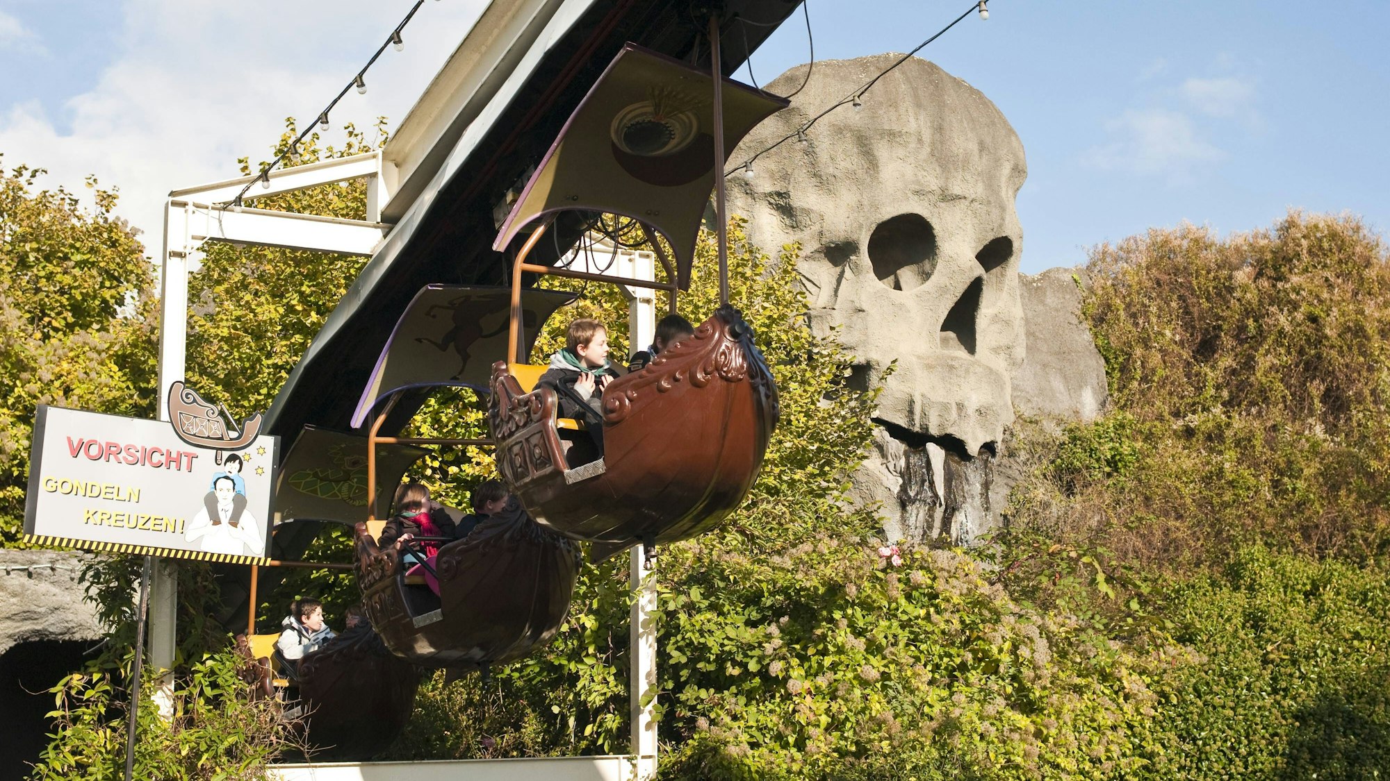 Gondeln passieren im Oktober 2009 einen riesigen, wasserspeienden Totenkopf im Phantasialand.