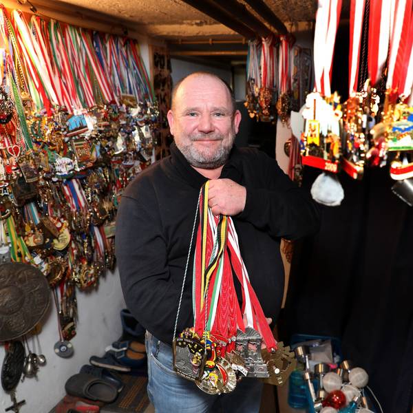 Der Karnevalist Frank Andes zeigt ein ganzes Bündel von Orden, an der Wand hängen mehrere Hundert weiterer Orden.