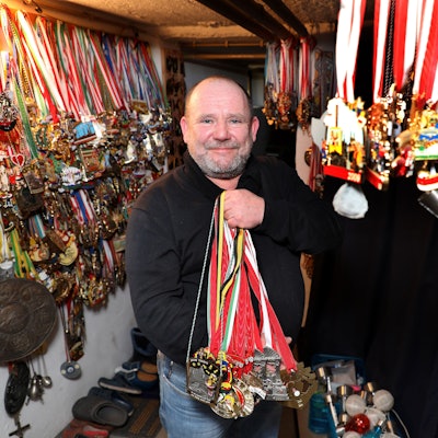Der Karnevalist Frank Andes zeigt ein ganzes Bündel von Orden, an der Wand hängen mehrere Hundert weiterer Orden.