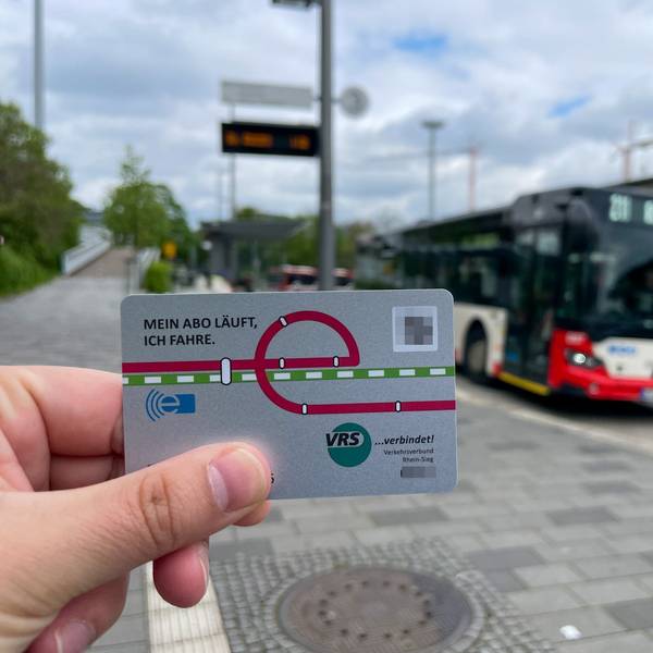 Im Vordergrund ist das Deutschlandticket zu sehen, im Hintergrund der Busbahnhof in Leverkusen-Mitte.