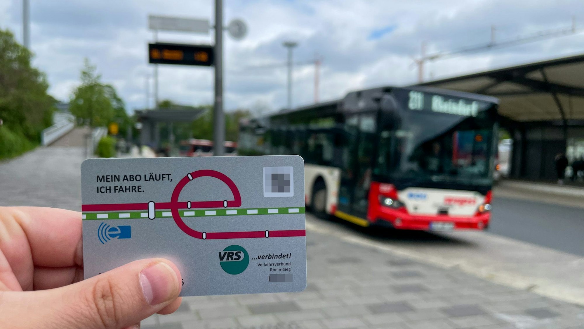 Im Vordergrund ist das Deutschlandticket zu sehen, im Hintergrund der Busbahnhof in Leverkusen-Mitte.