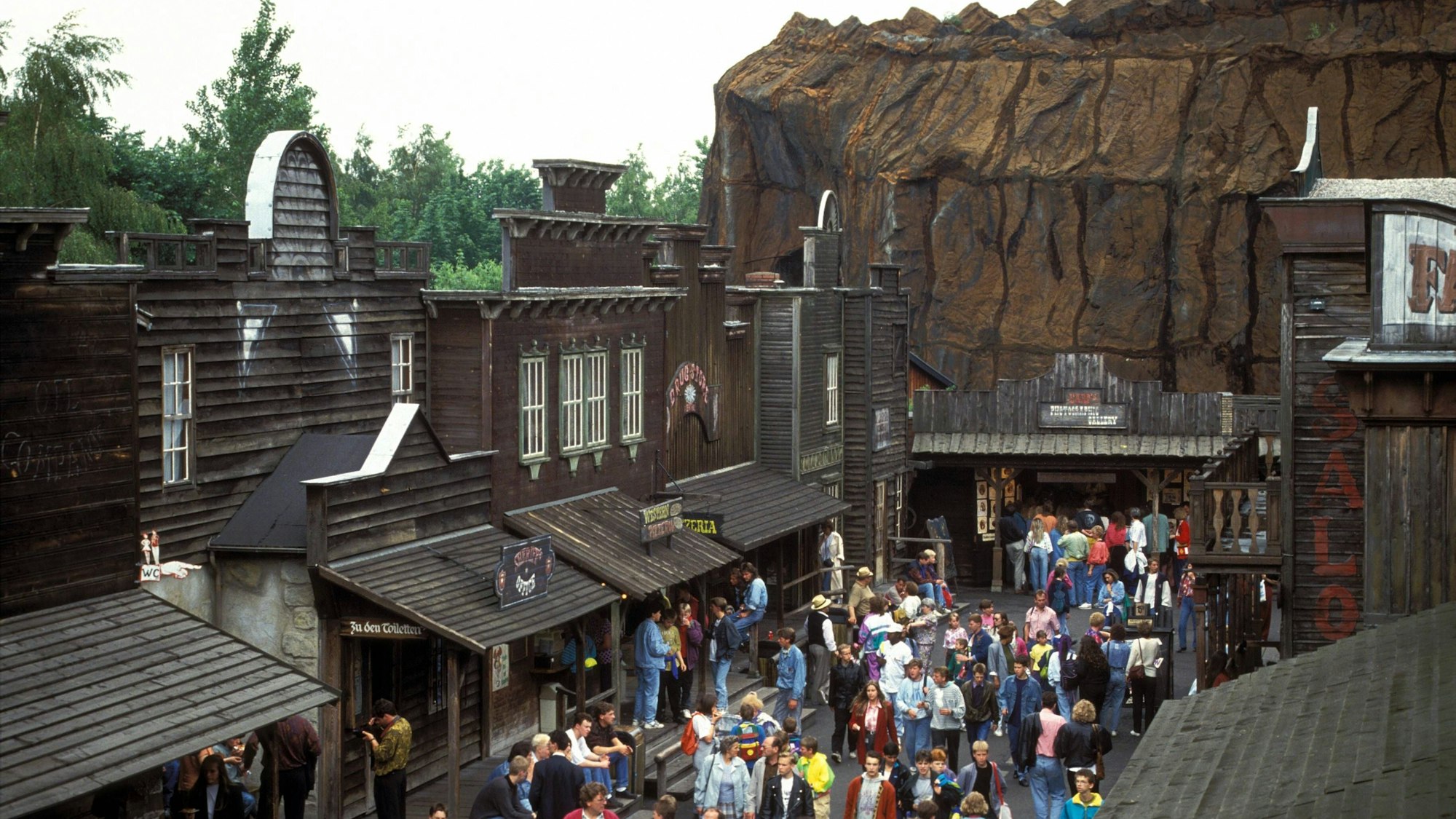Freizeitpark-Gäste strömen im Juni 1991 durch die Westernstadt im Phantasialand.