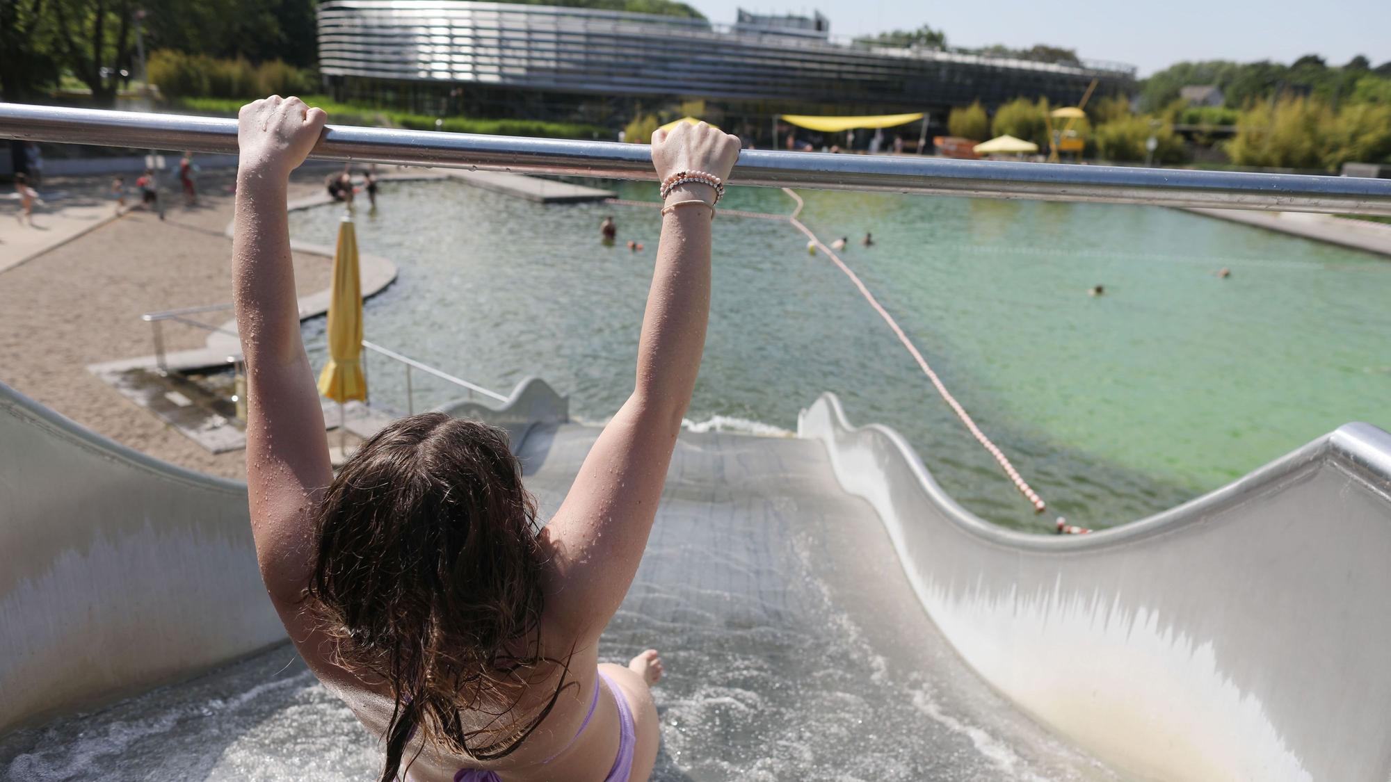 Ein Kind rutscht im Lentpark ins Wasserbecken