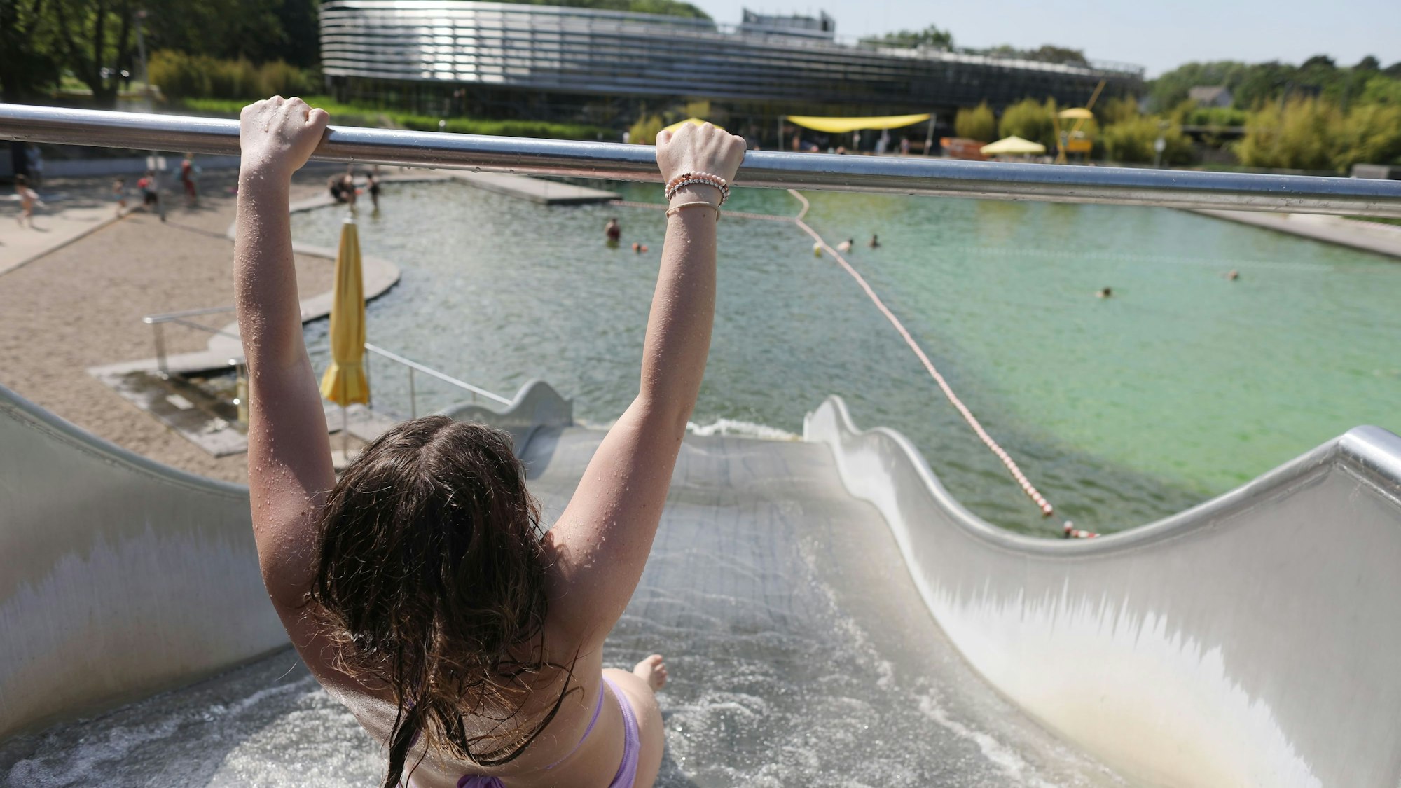Ein Kind rutscht im Lentpark ins Wasserbecken