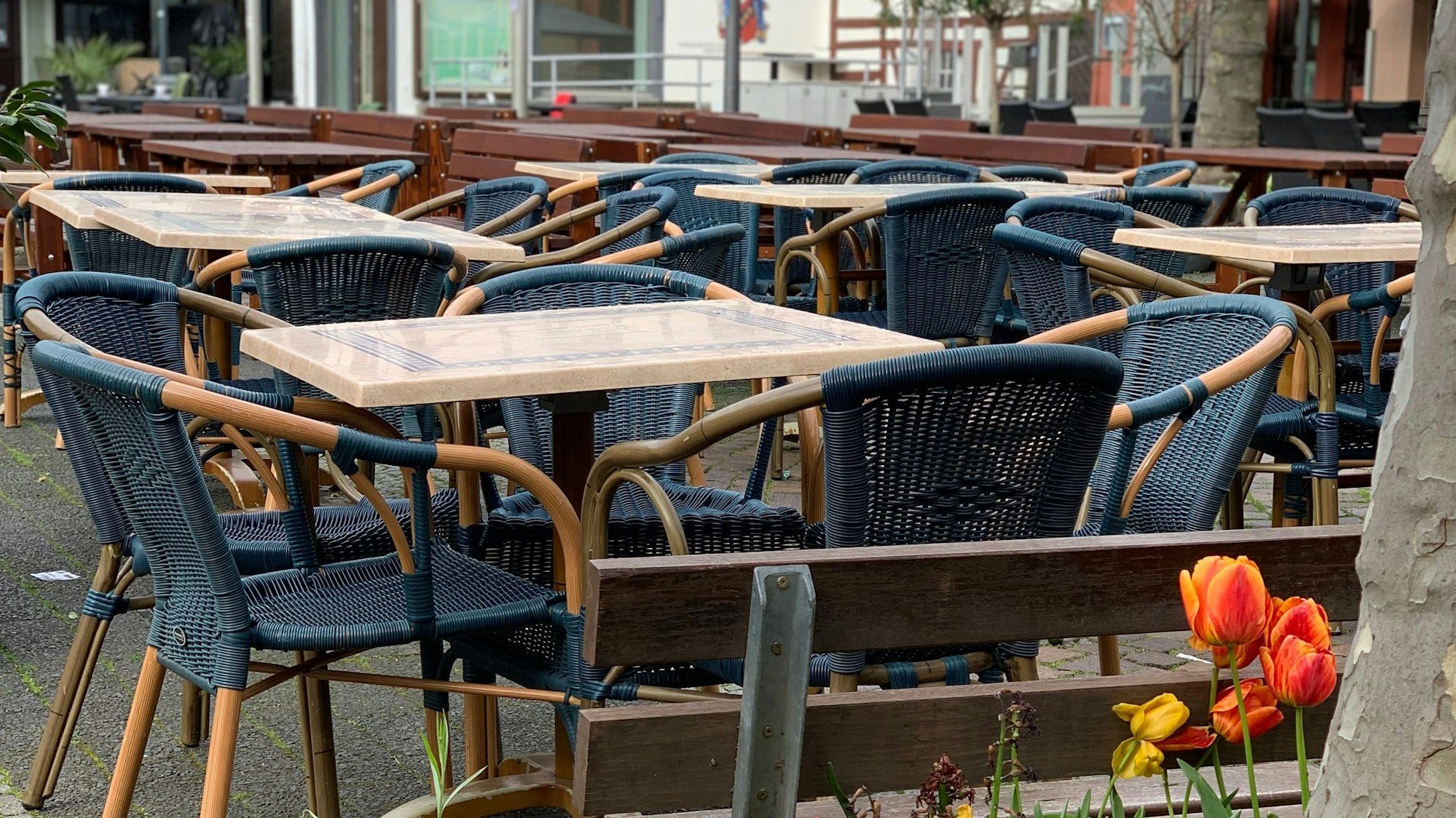 Leere Tische und Stühle vor einem Restaurant in Euskirchen.