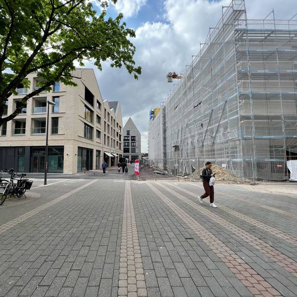 Die Porzer Innenstadt mit drei neuen Gebäuden und einer Fußgängerin.
