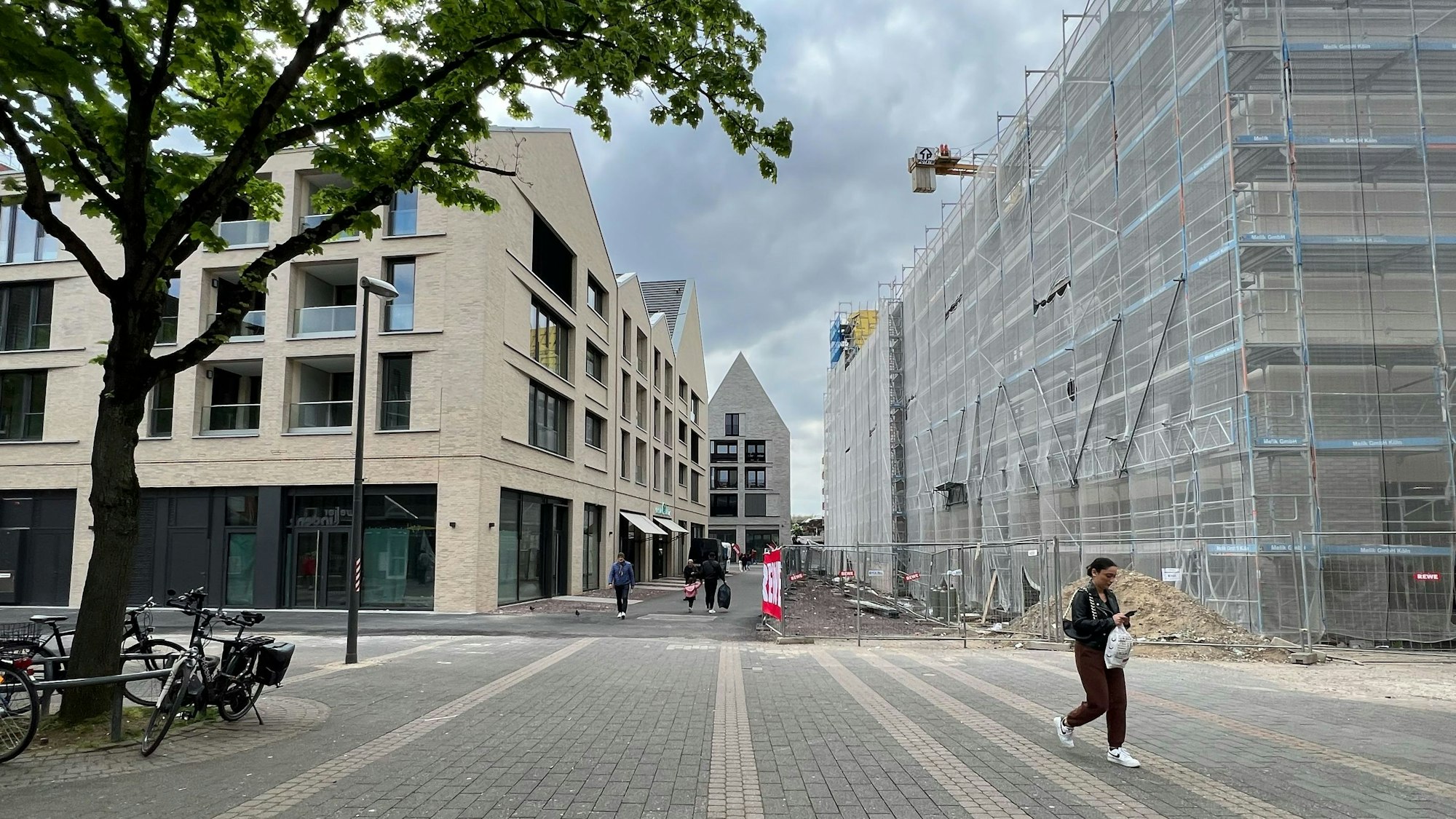 Zwei neue mehrstöckige Gebäude sind zu sehen. Das rechte ist noch hinter Gerüsten und Planen verborgen.