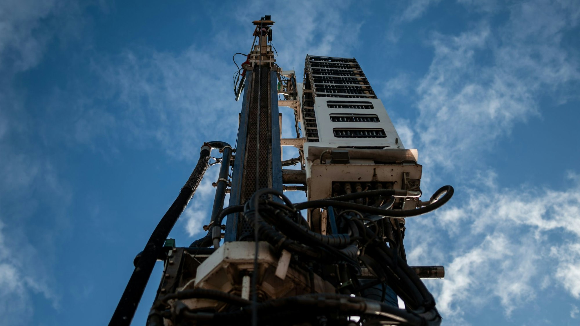 Eine Bohranlage ist zu sehen vor blauem Himmel.