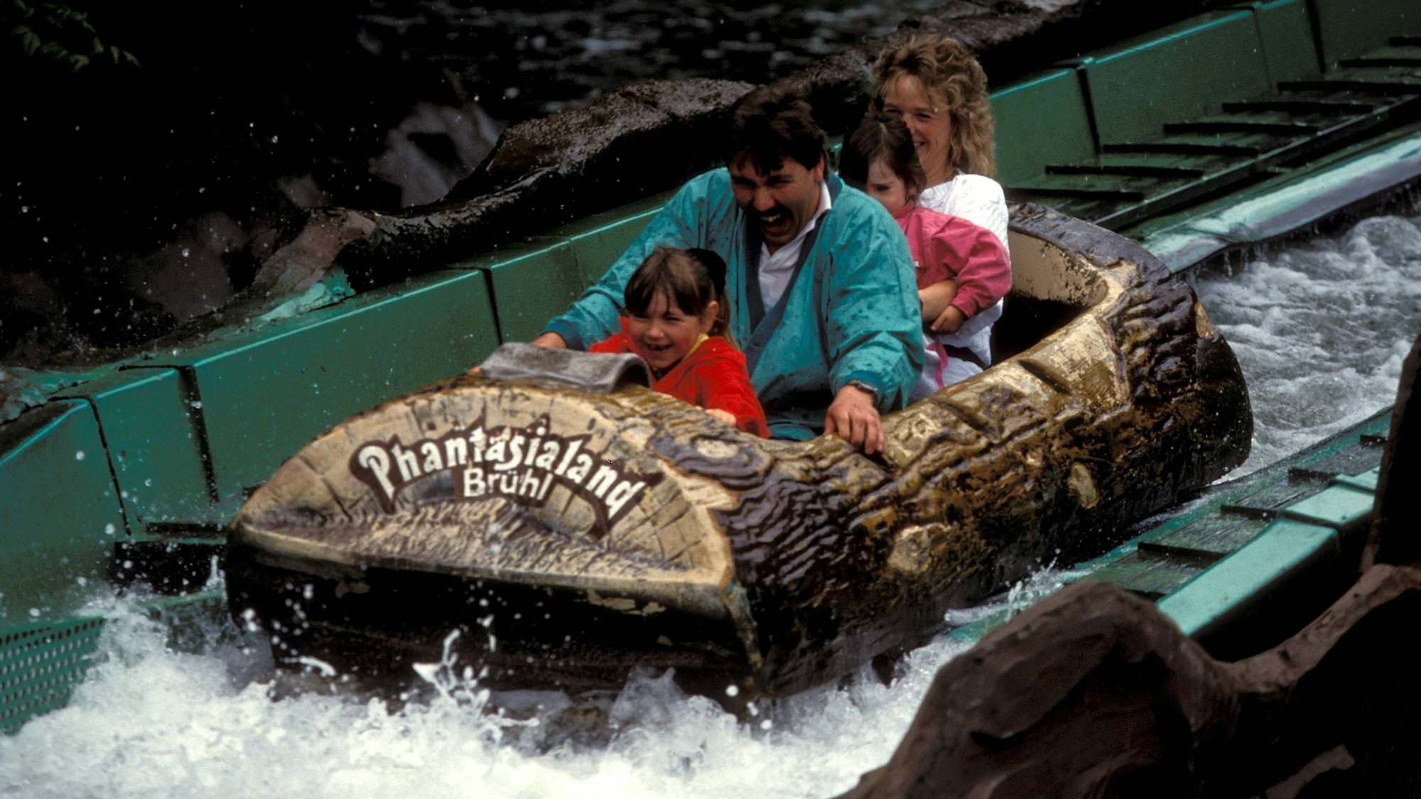 Eine Familie wird im Juni 1991 nach dem Drop in der Wildwasserbahn Stonewash Creek im Phantasialand nassgespritzt.
