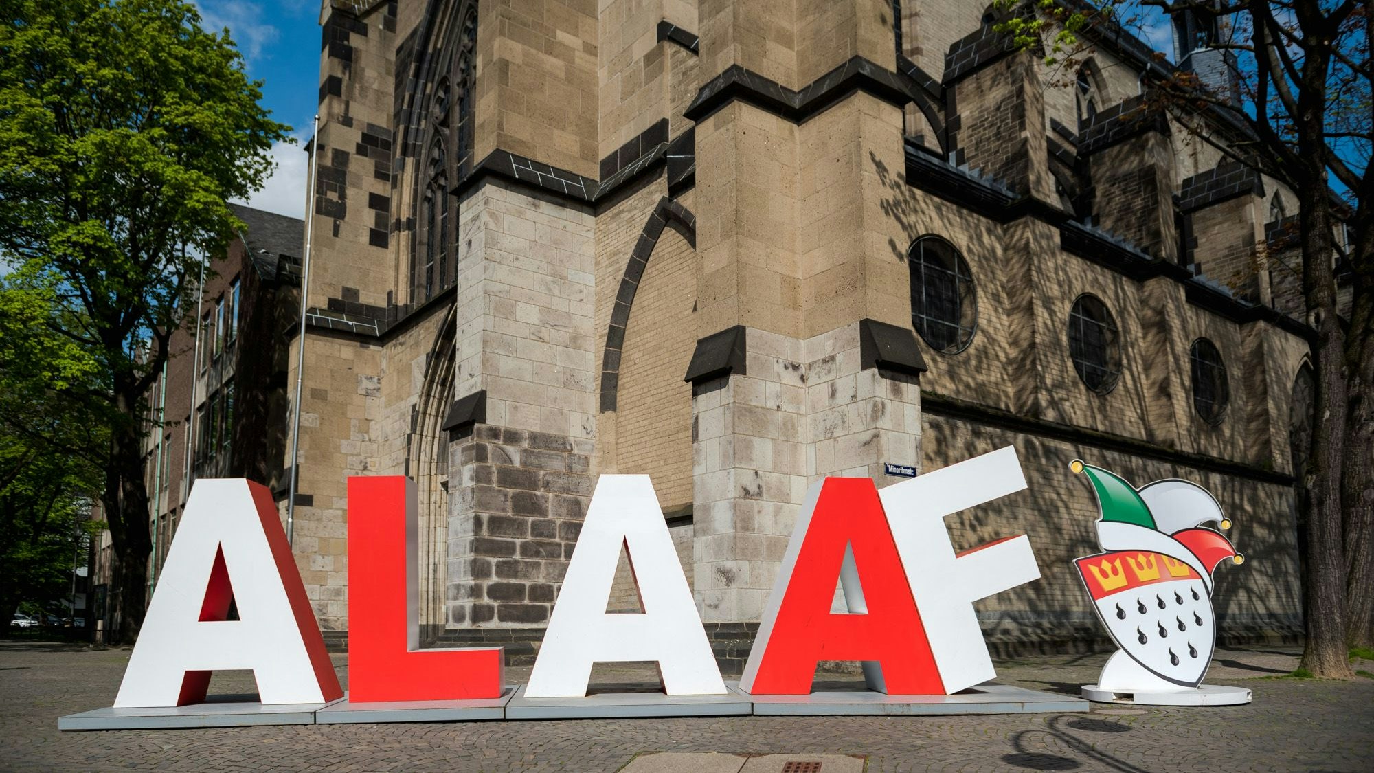 Schriftzug mit zwei Meter hohen roten und weißen Buchstaben vor der Kirche