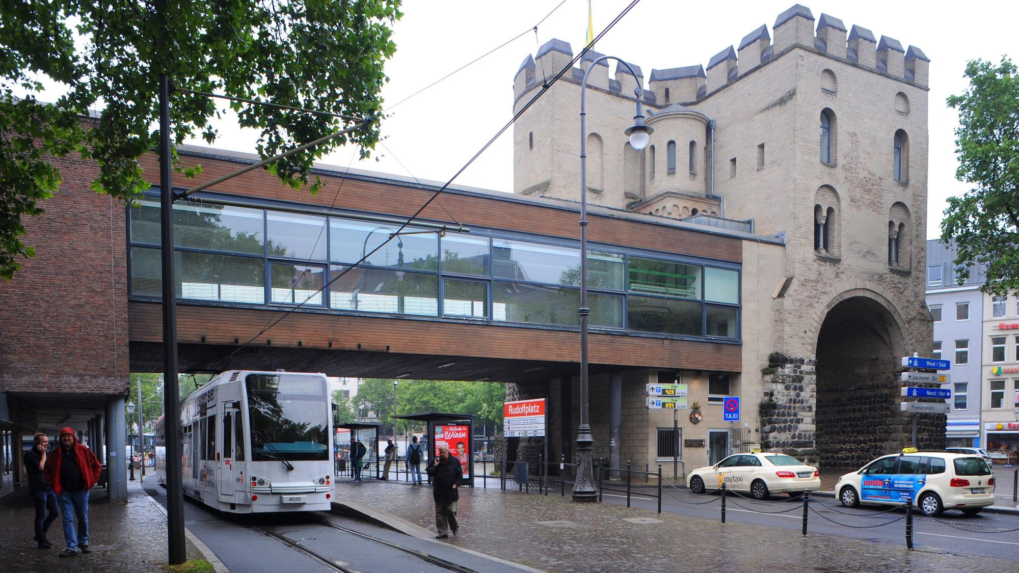 Das Bild zeigt die frühere Brücke über die Hahnenstraße, darunter fahren Autos und eine Bahn.