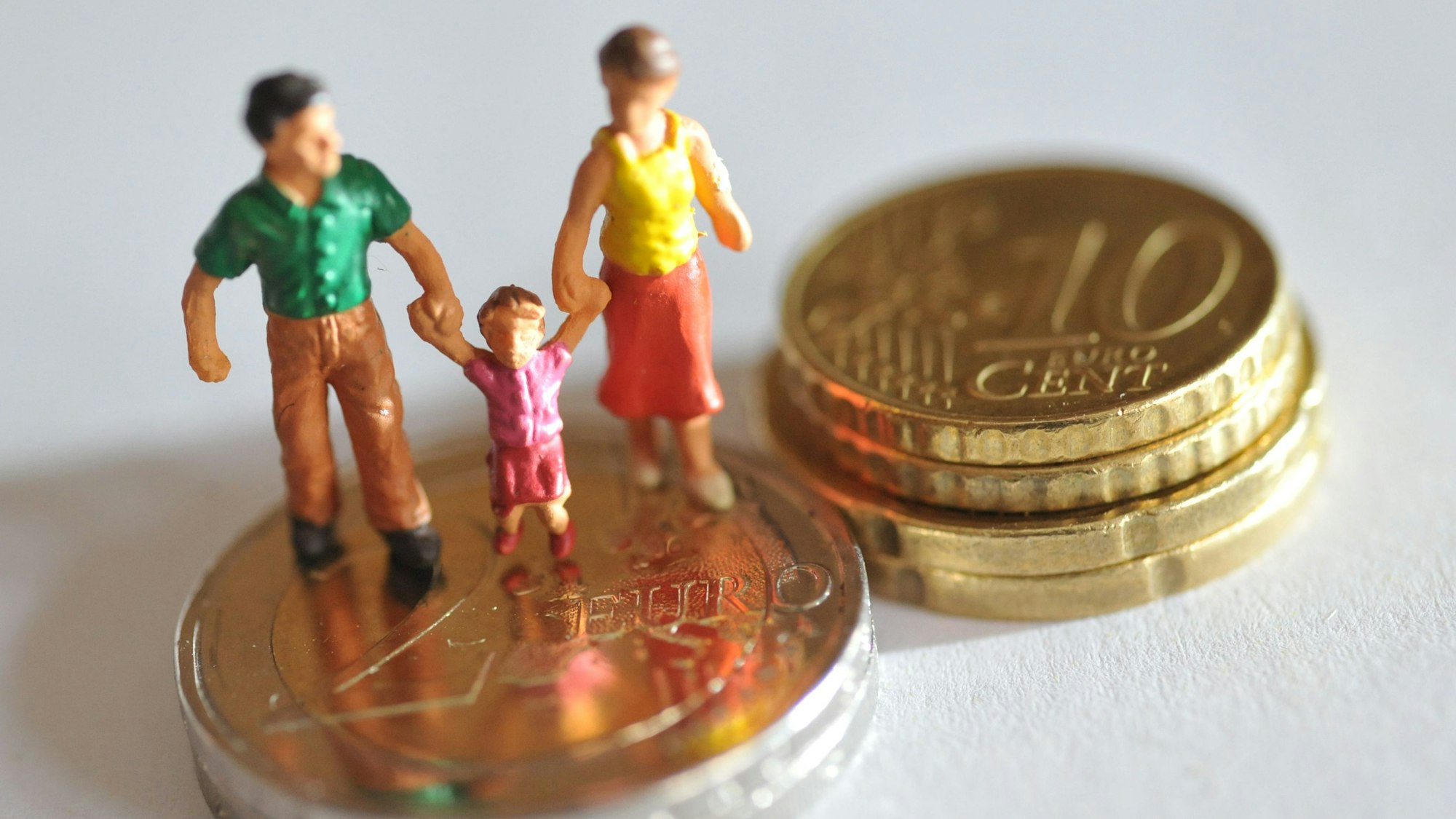 Eine Figur, die ein Paar mit kleinem Kind zeigt, steht auf Euro-Münzen.