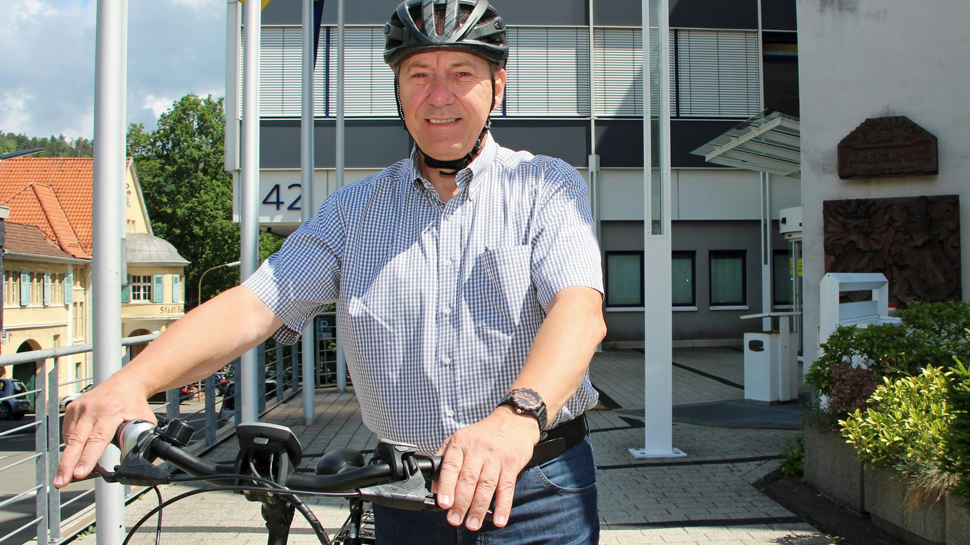 Landrat Jochen Hagt steht mit einem Fahrrad vor dem Kreishaus in Gummersbach.