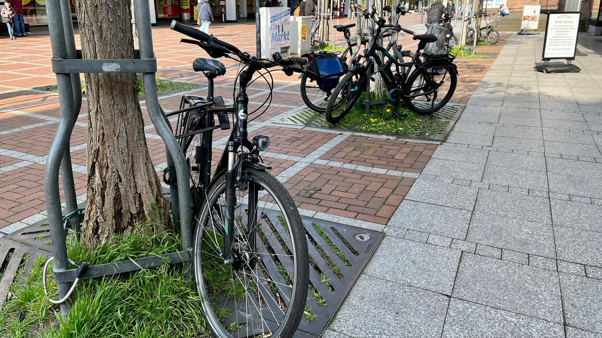 Fahrräder am Wiesdorfer Platz, die an Baumgerüsten angeschlossen sind.
