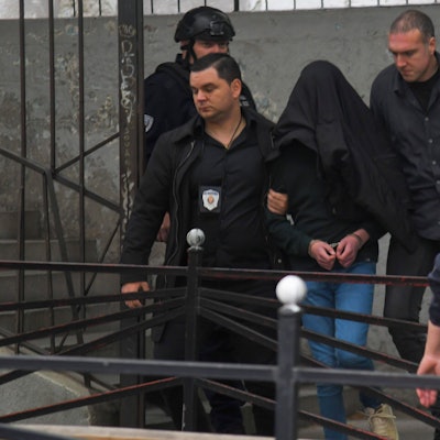 Der Verdächtige (m.) wird von der Polizei an einer Grundschule eskortiert. Ein Schüler hat in einer Belgrader Schule auf Mitschüler und Schulpersonal geschossen und dabei mehrere Menschen getötet.