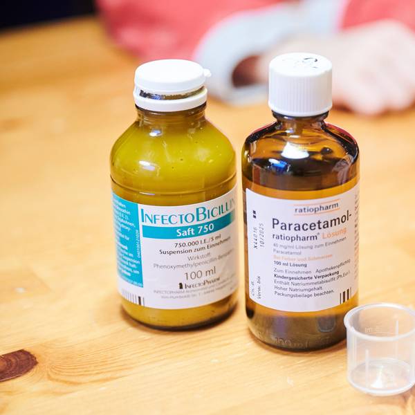 Auf einem Tisch stehen Schmerzsaft und Penicillin für Kinder.