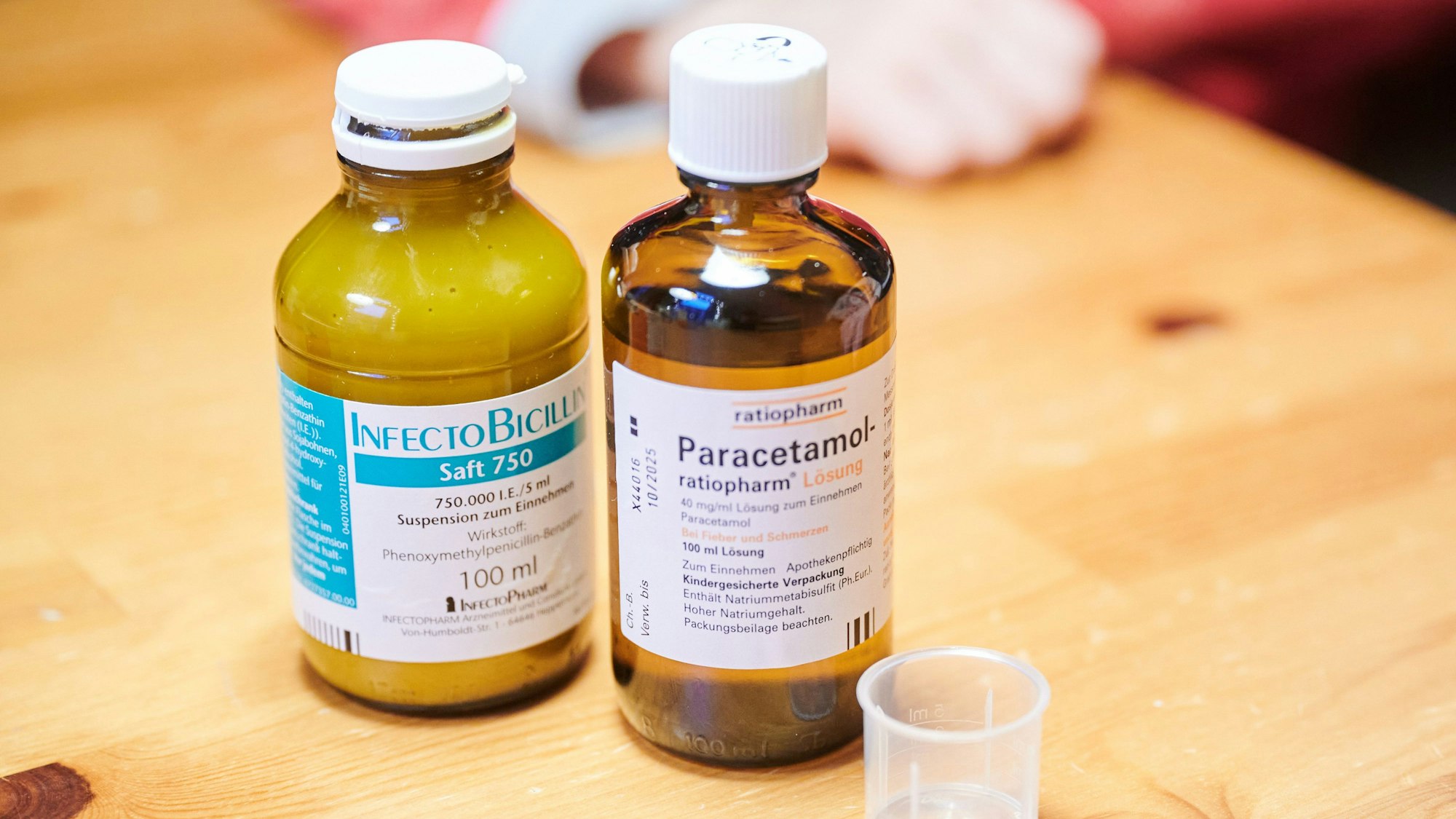 Auf einem Tisch stehen Schmerzsaft und Penicillin für Kinder.