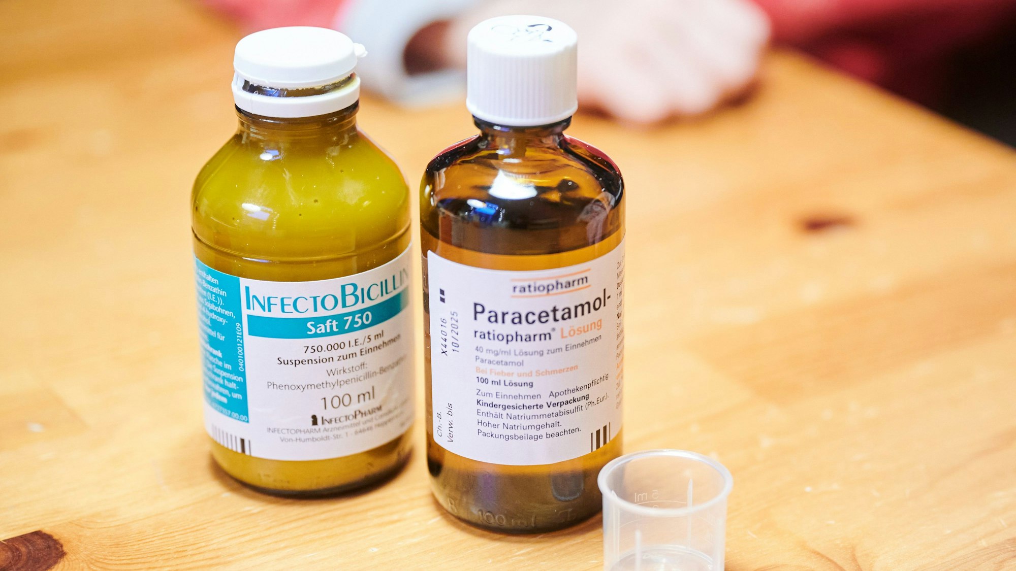 Auf einem Tisch stehen Schmerzsaft und Penicillin für Kinder.