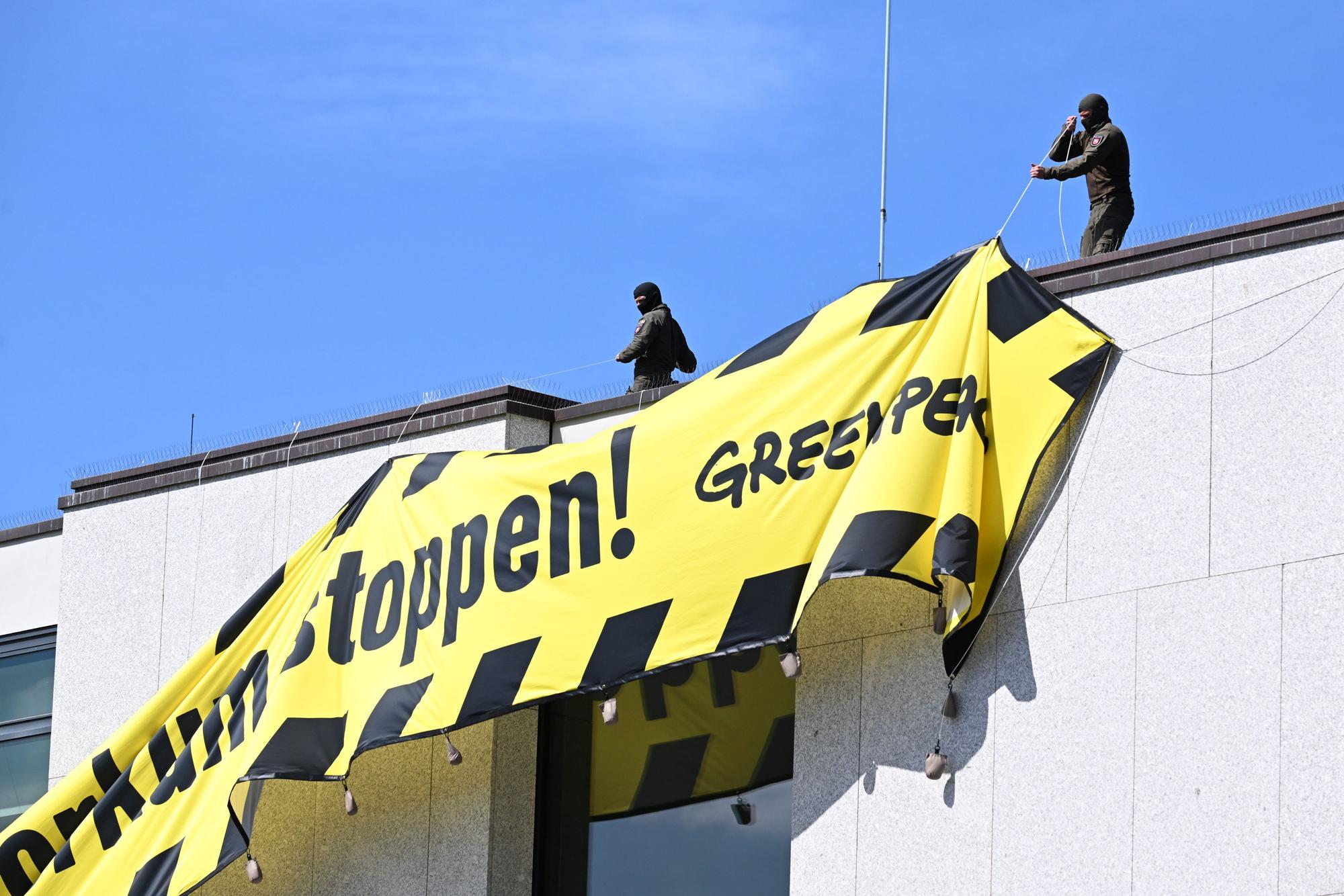 Mitglieder einer Einheit des SEK der Polizei stehen auf dem Dach des niedersächsischen Landtags und entfernen ein Transparent von Greenpeace gegen eine Gasbohrung vor der Nordseeinsel Borkum.